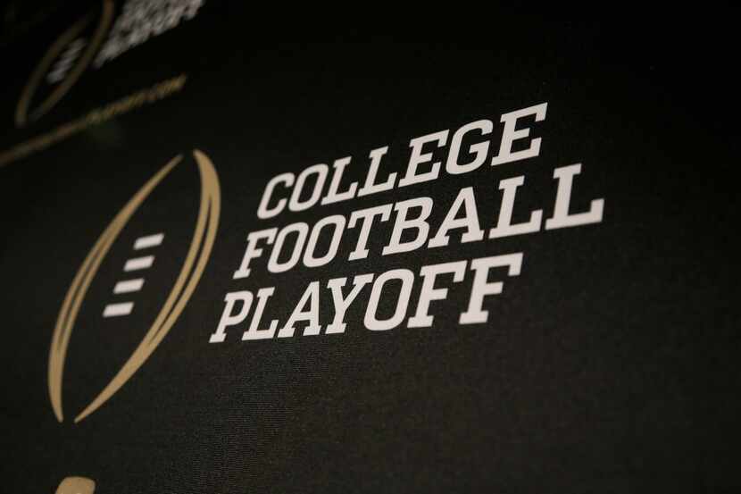 The College Football Playoff logo is printed across a backdrop during a news conference...