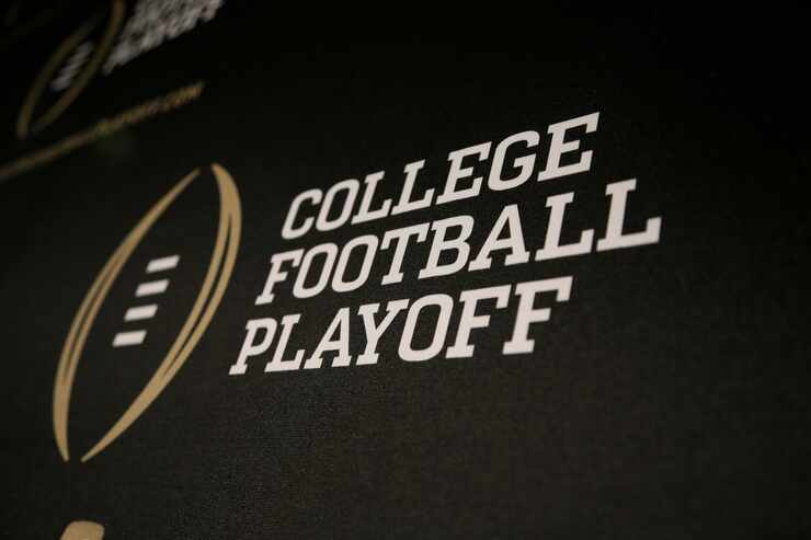FILE - The College Football Playoff logo is printed across a backdrop during a news...