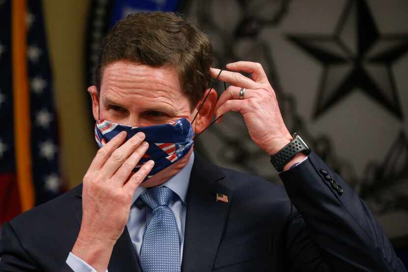 Dallas County Judge Clay Jenkins displays an improvised clothe face mask made with a bandana...