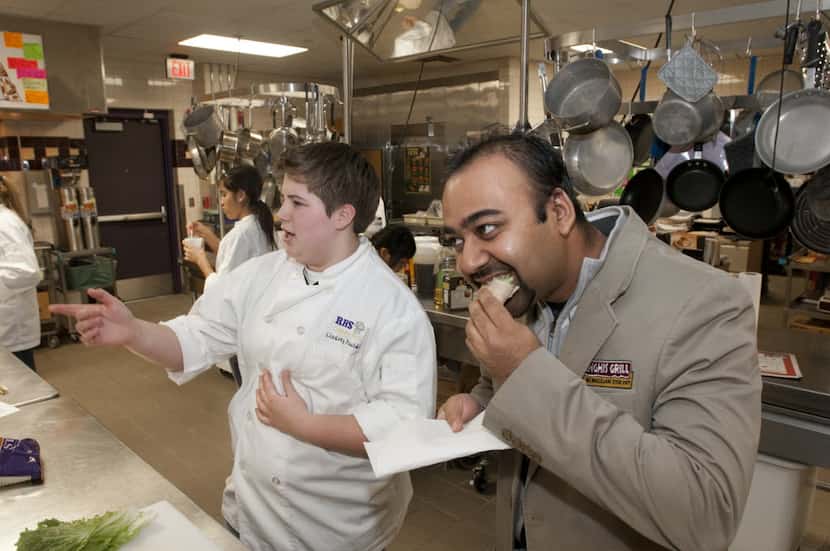 Ron Parikh, Chief Marketing Officer for Genghis Grill, right, tries a dish by Richardson...