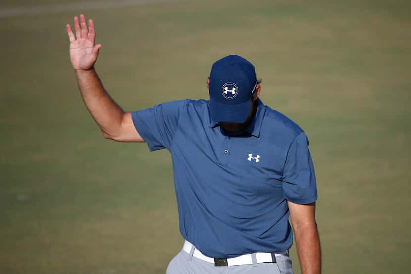 Former Dallas Cowboys quarterback Tony Romo waves to fans after making a birdie putt on the...