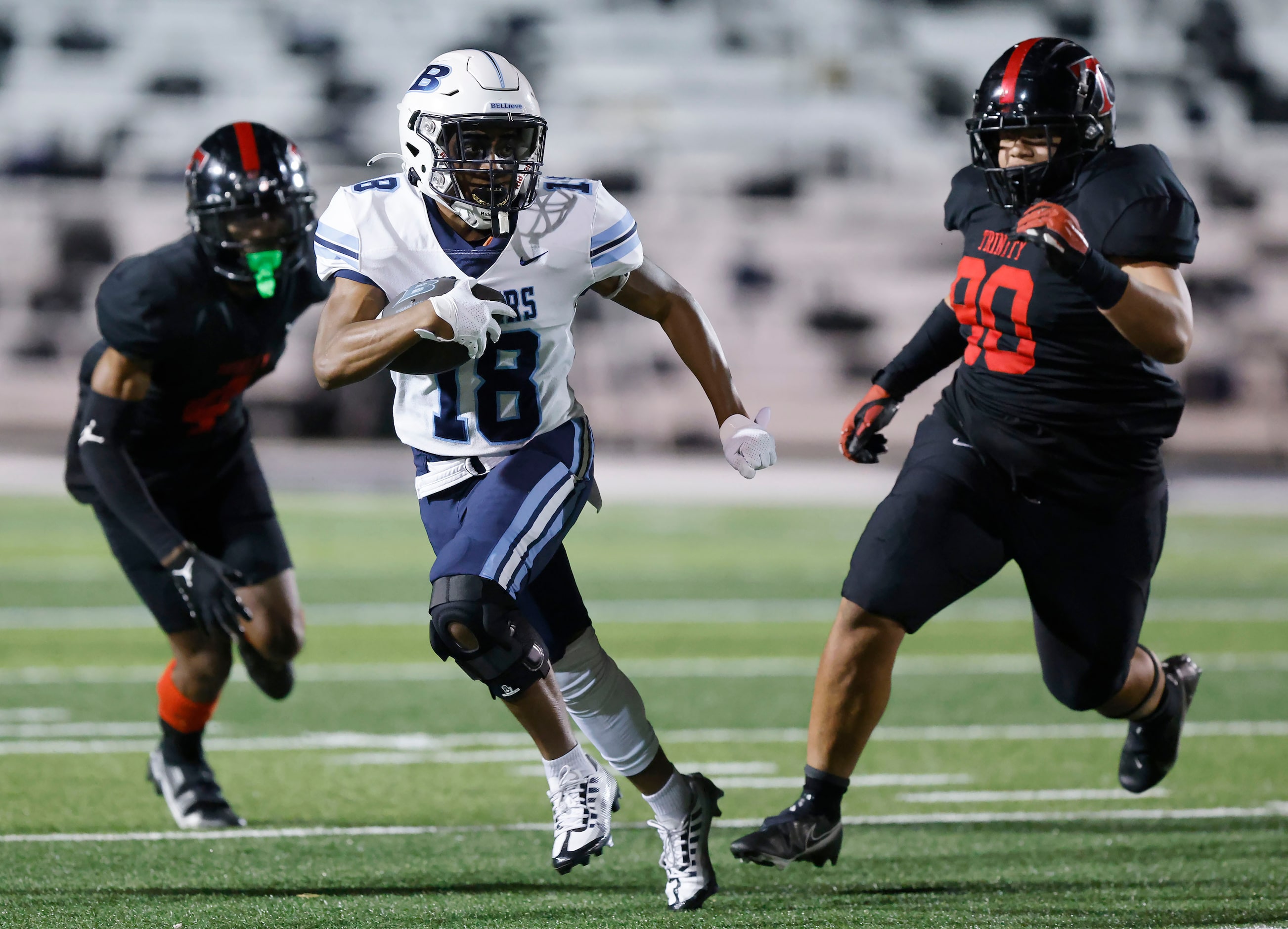 Hurst L.D. Bell running back Gracien Anto (8) splits a pair of Euless Trinity defenders...