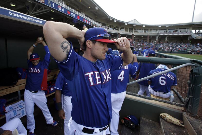 Texas Rangers' Brad Snyder, center, prepares to take the field during a spring training...