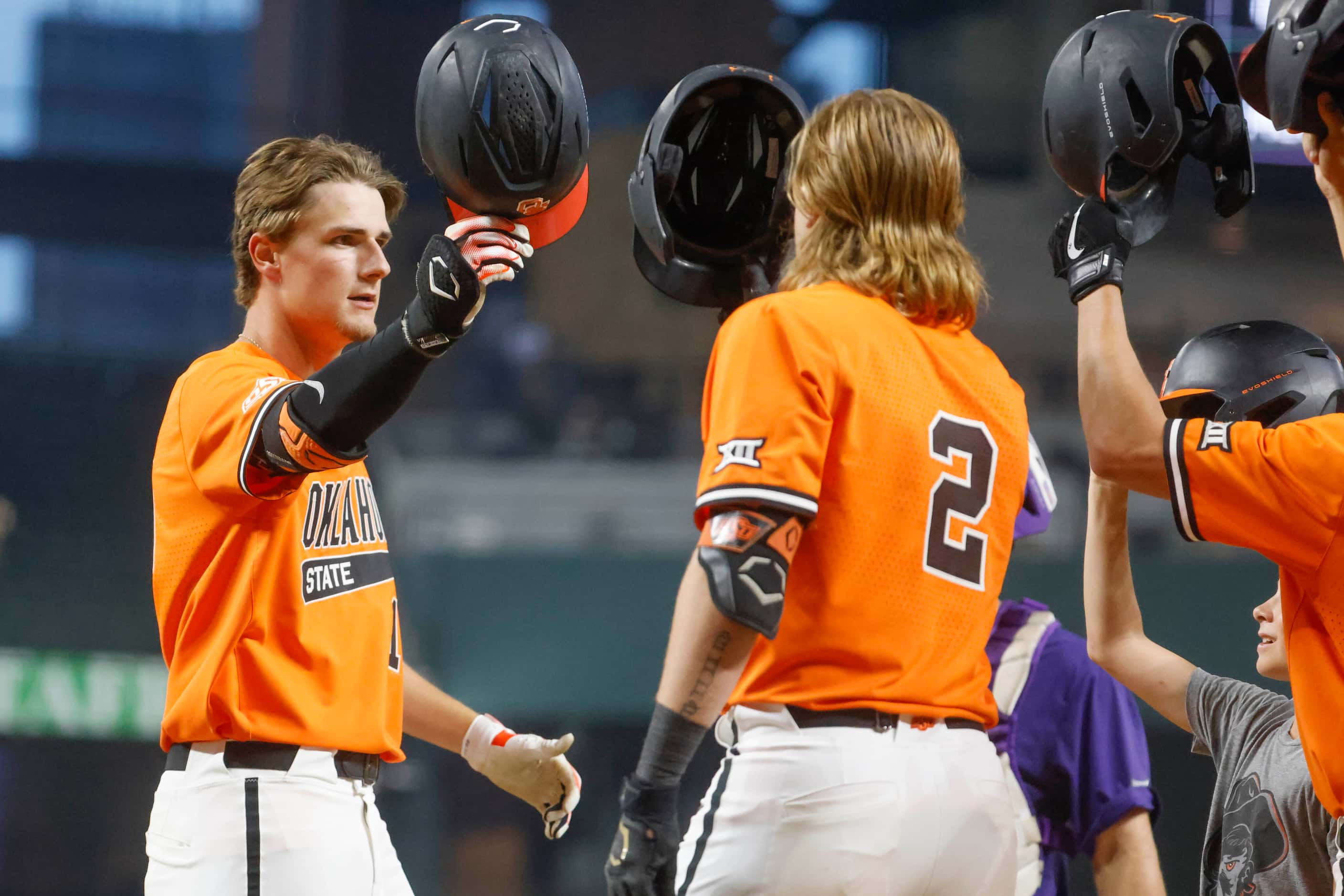 Oklahoma St. outfielder Nolan Schubart (left) celebrate with his teammates after hitting a...