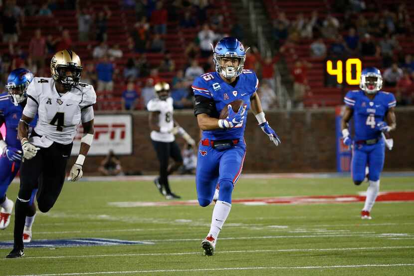 FILE - SMU defensive back Jordan Wyatt (15) returns an interception for a touchdown past UCF...