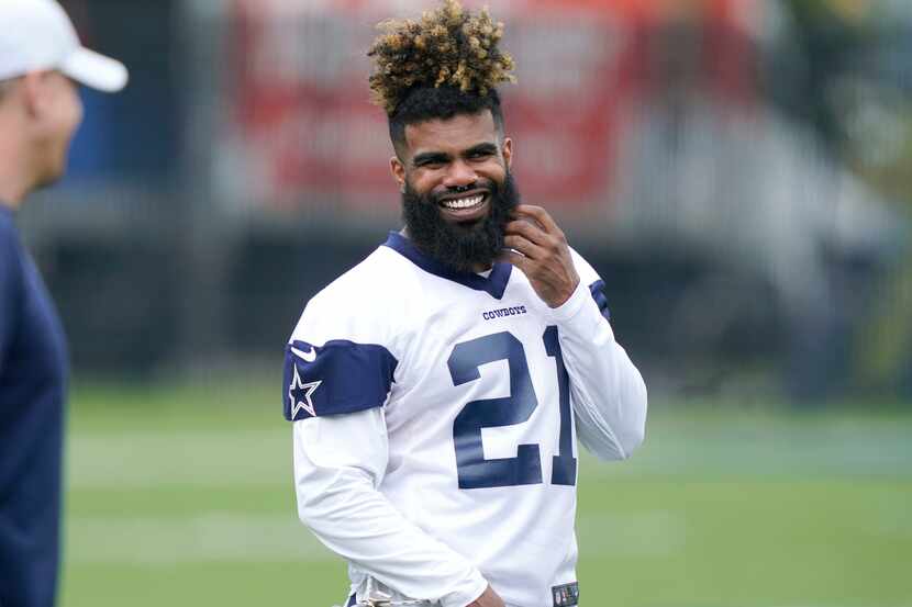Dallas Cowboys running back Ezekiel Elliott smiles as he warms up during an NFL football...