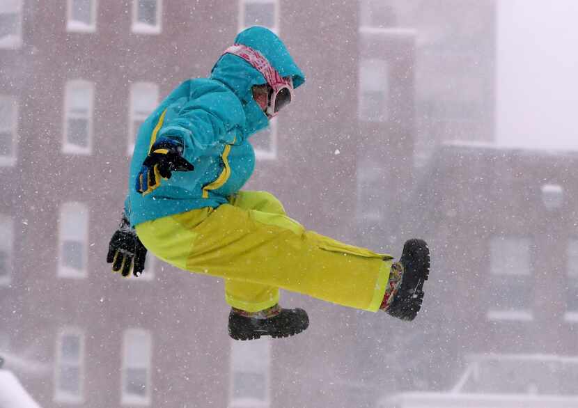 Carina Stack, 6, jumps from a snow bank while enjoying a snowstorm, Thursday, Feb 9, 2017,...