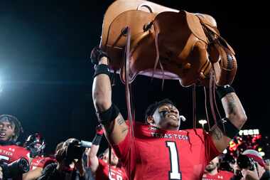 Texas Tech defensive back Dadrion Taylor-Demerson (1) holds up the Saddle Trophy after the...