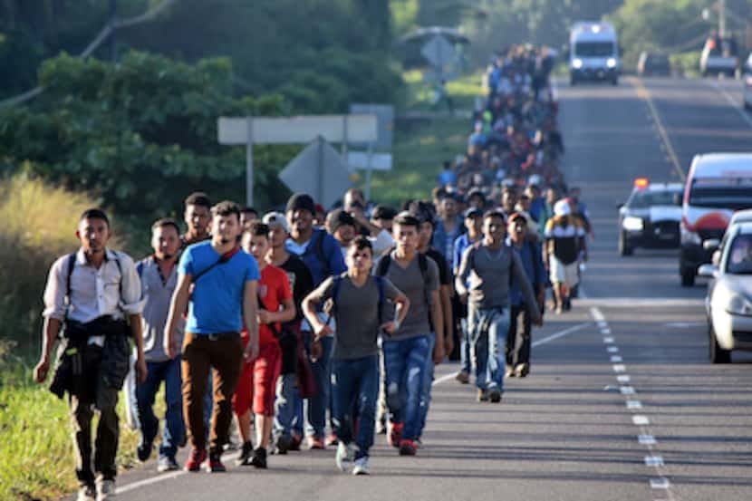 Un grupo de inmigrantes —en su mayoría centroamericanos— camina por una carretera de México...