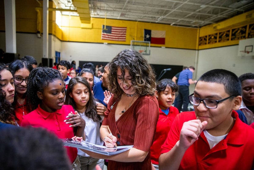 O'Neil signs autographs after performing for the sixth-graders.