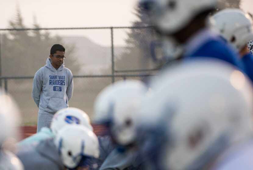 Sunnyvale High School sophomore Ryan Mathew, the football team manager, watches as offensive...