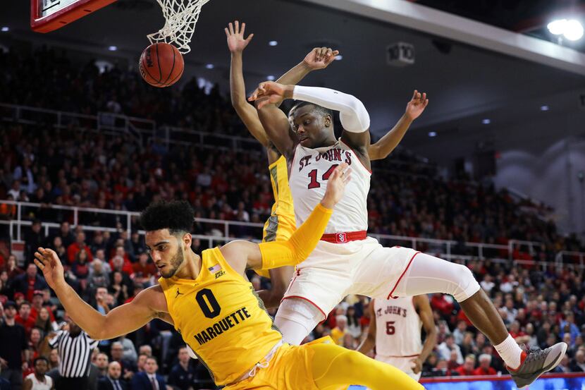 St. John's guard Mustapha Heron scores on Marquette Guard Markus Howard during the second...