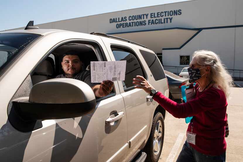 Volunteer Kathleen Campbell, 76, with the organization March to the Polls, reaches for the...