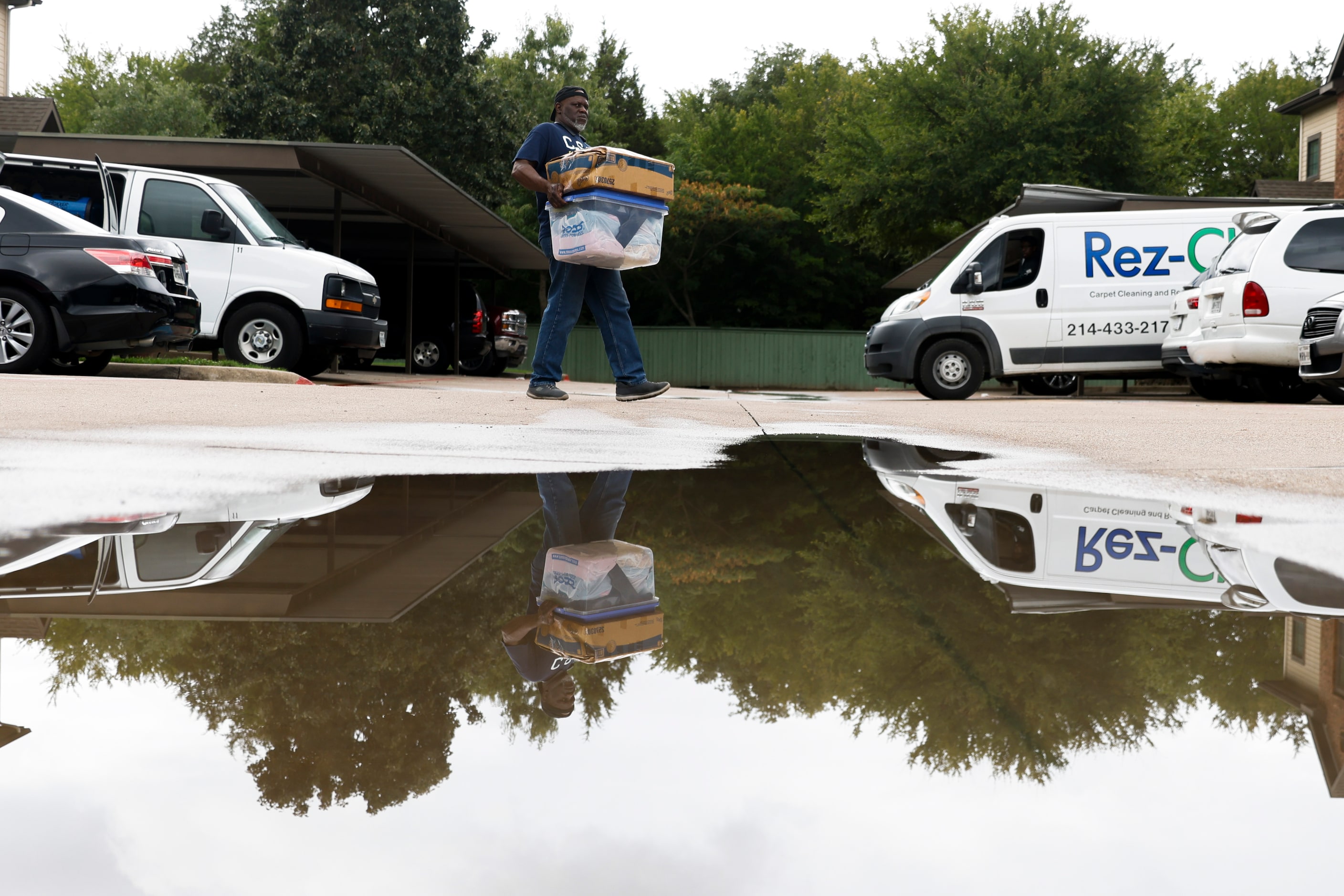 Troy H. shifts a friend's belongings out of their house at Spring Oaks Apartments in Balch...