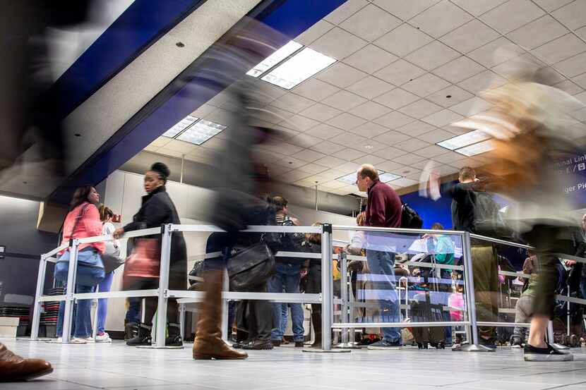 Travelers make their way through DFW International Airport's Terminal C security.