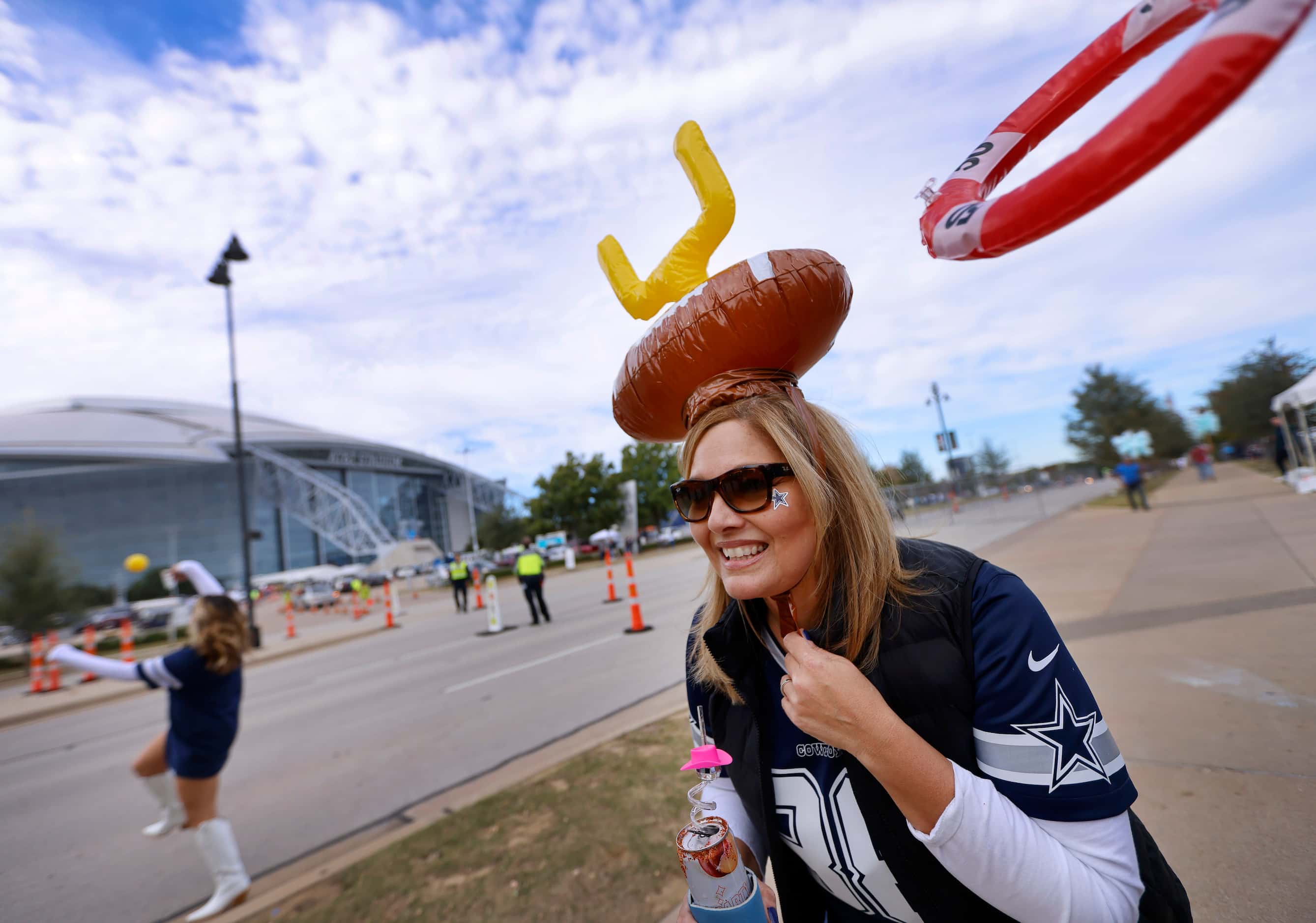 Dallas Cowboys fan Noemi Rosete of Arlington attempts to catch an inflatable ring with her...