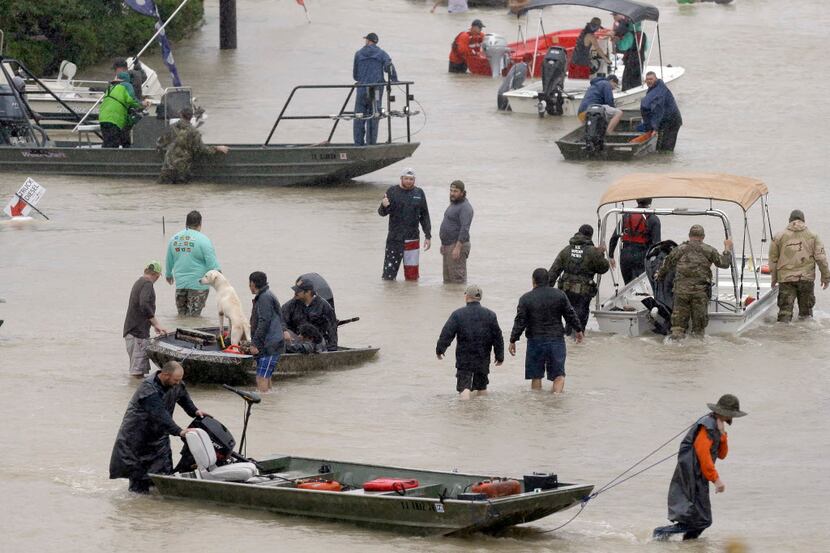 People and rescue boats lined a street in Houston as they helped evacuate residents amid a...