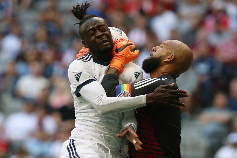 Vancouver Whitecaps' Kei Kamara, left, heads the ball against Colorado Rapids goalkeeper Tim...