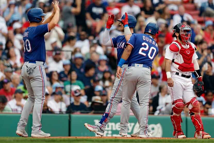 Texas Rangers' Mitch Garver, center left, celebrates his three-run home run that also drove...