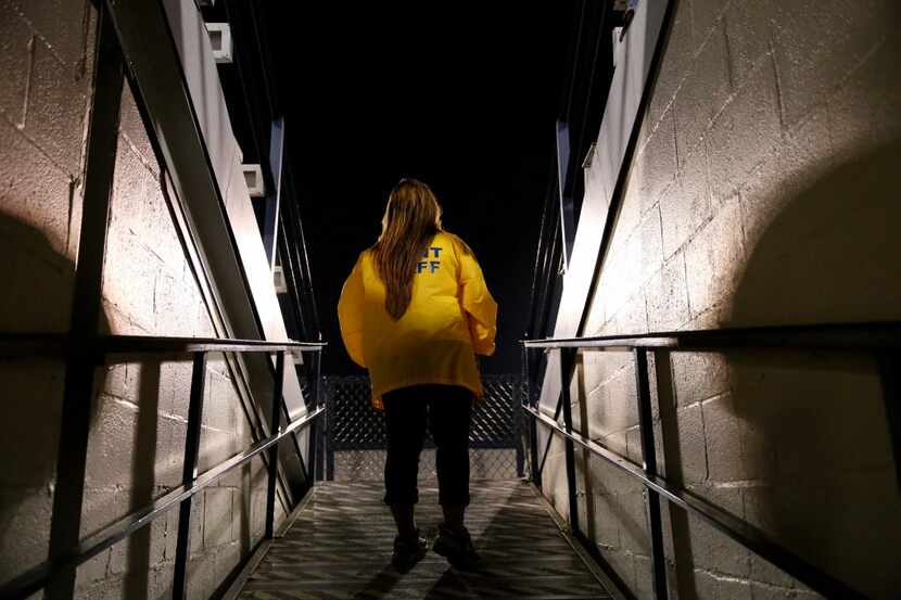 Event security Dora De La Cruz watches from the tunnel during a weather delay as severe...