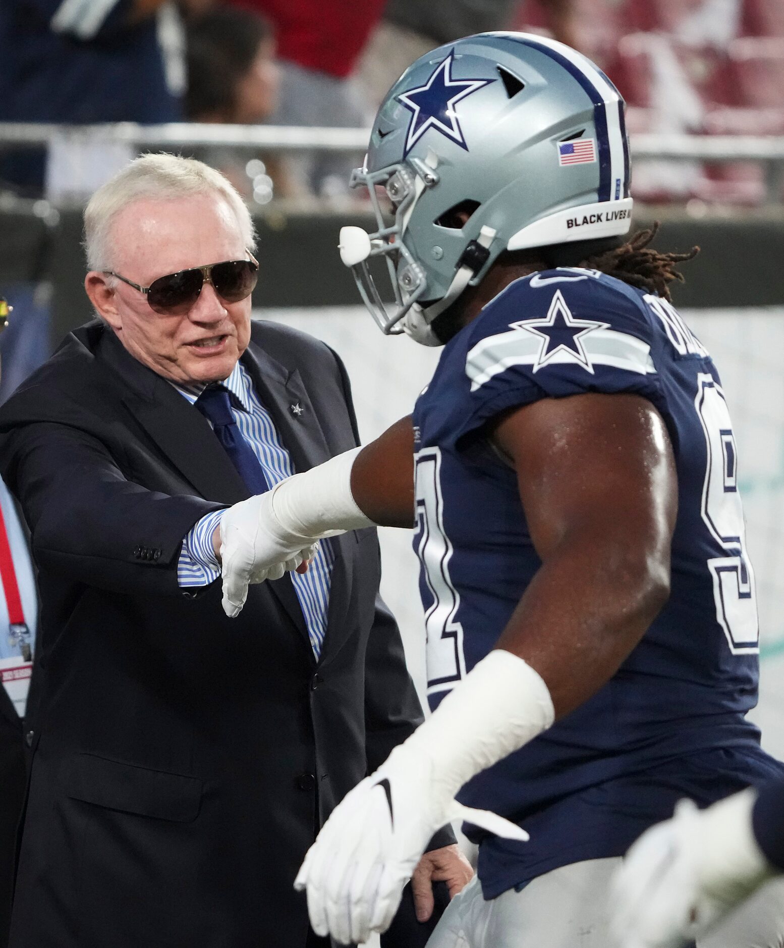 Dallas Cowboys owner and general manager Jerry Jones fist bumps defensive tackle Osa...