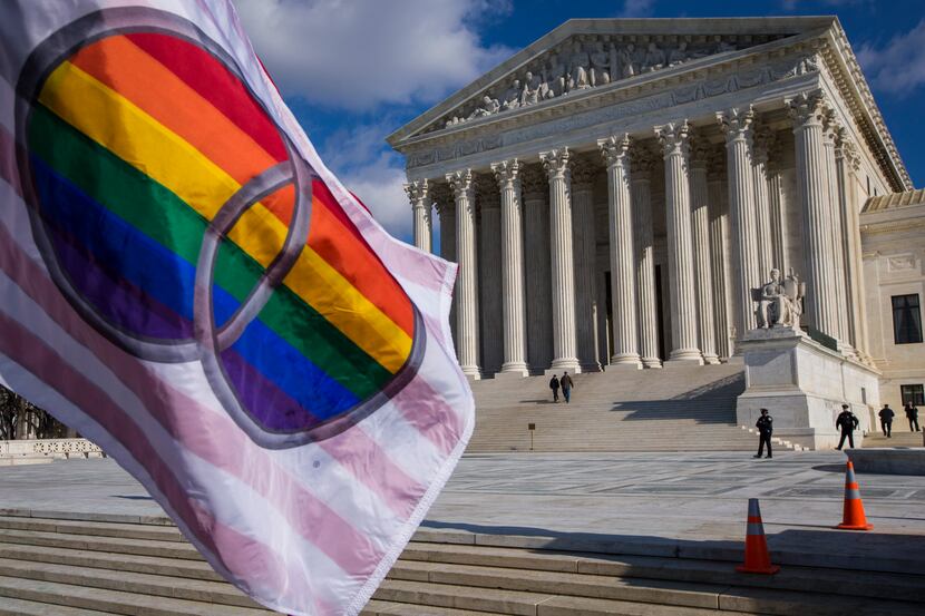 A flag supporting gay marriage was flown by demonstrators Friday in front of the Supreme...