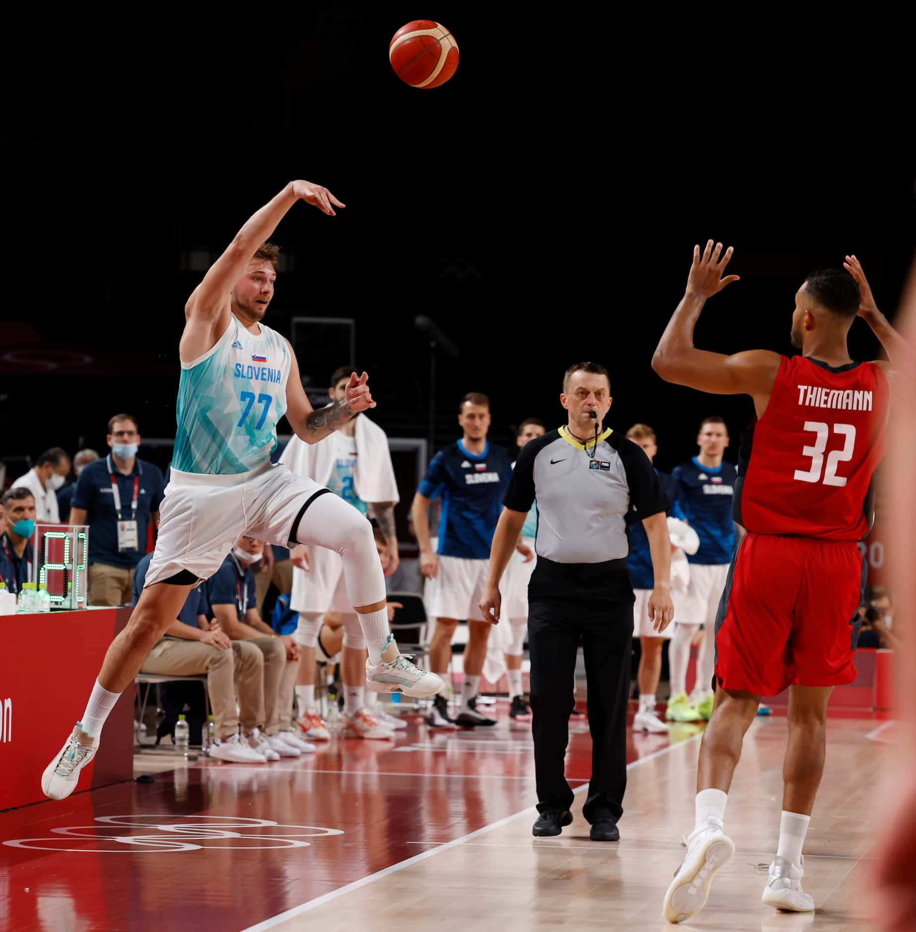 Slovenia’s Luka Doncic (77) saves a ball before going out of bounds in front of Germany’s...