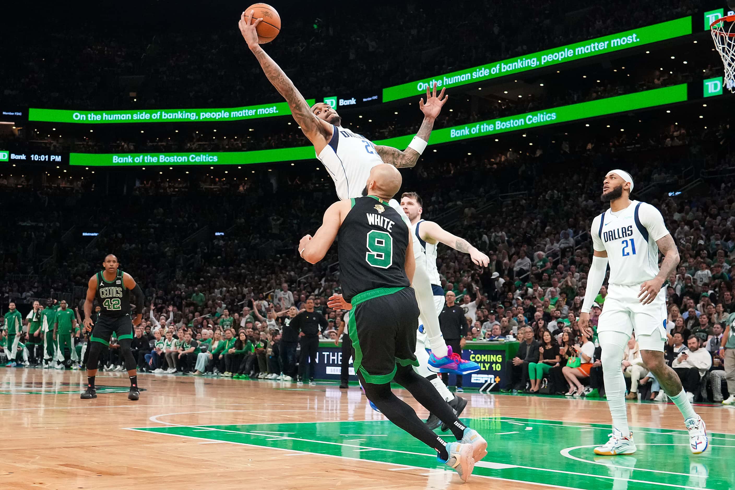 Dallas Mavericks forward P.J. Washington (25) reaches for a rebound over Boston Celtics...