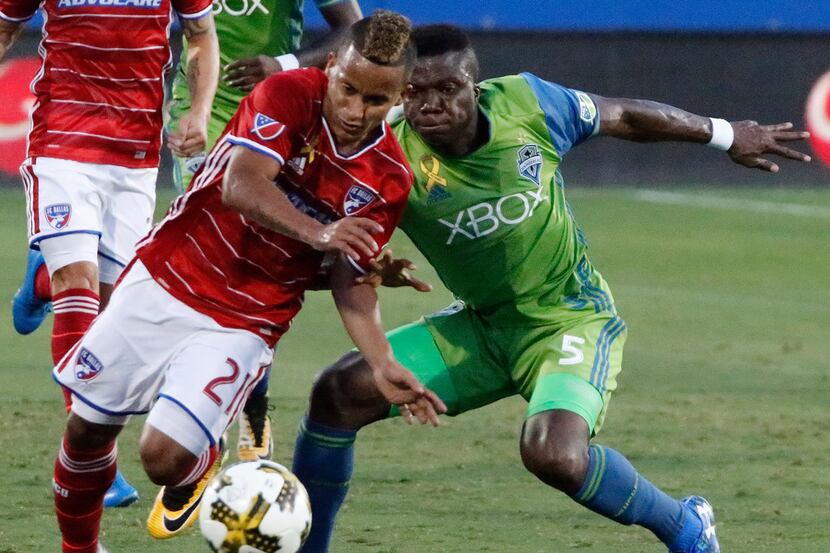 FC Dallas midfielder Michael Barrios (21) avoids being tripped by Seattle Sounders defender...