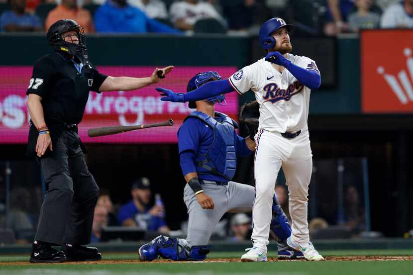 Texas Rangers first baseman Jared Walsh (21) tosses his bat after hitting a two-run home run...