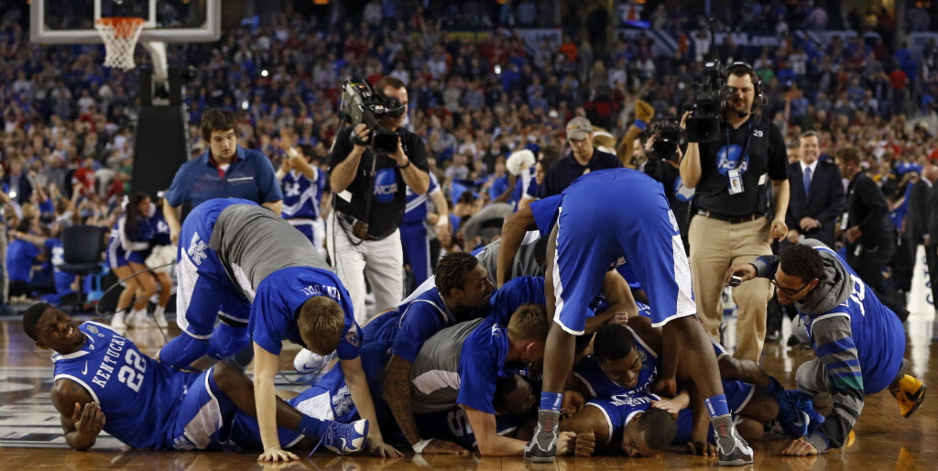 Kentucky Wildcats dog piles Kentucky Wildcats guard Aaron Harrison (2) after defeating the...