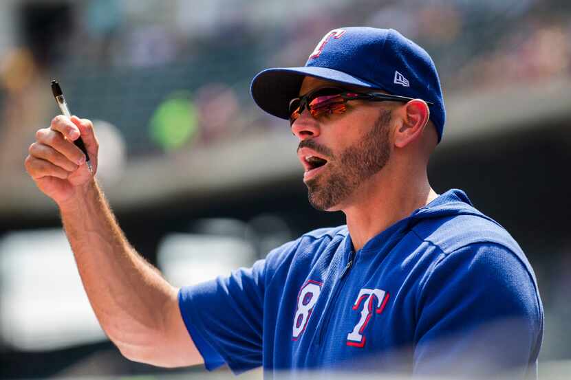 Texas Rangers manager Chris Woodward (8) gives instructions in the dugout during the first...