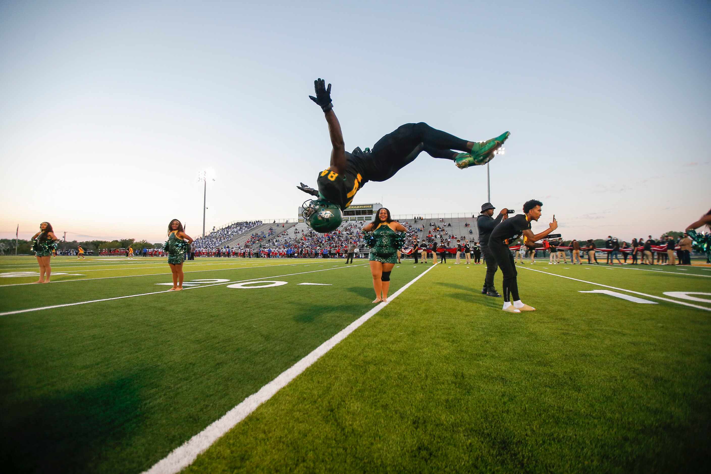 DeSoto senior wide receiver Marquis Wortham (84) does a back flip as he leads his teammates...