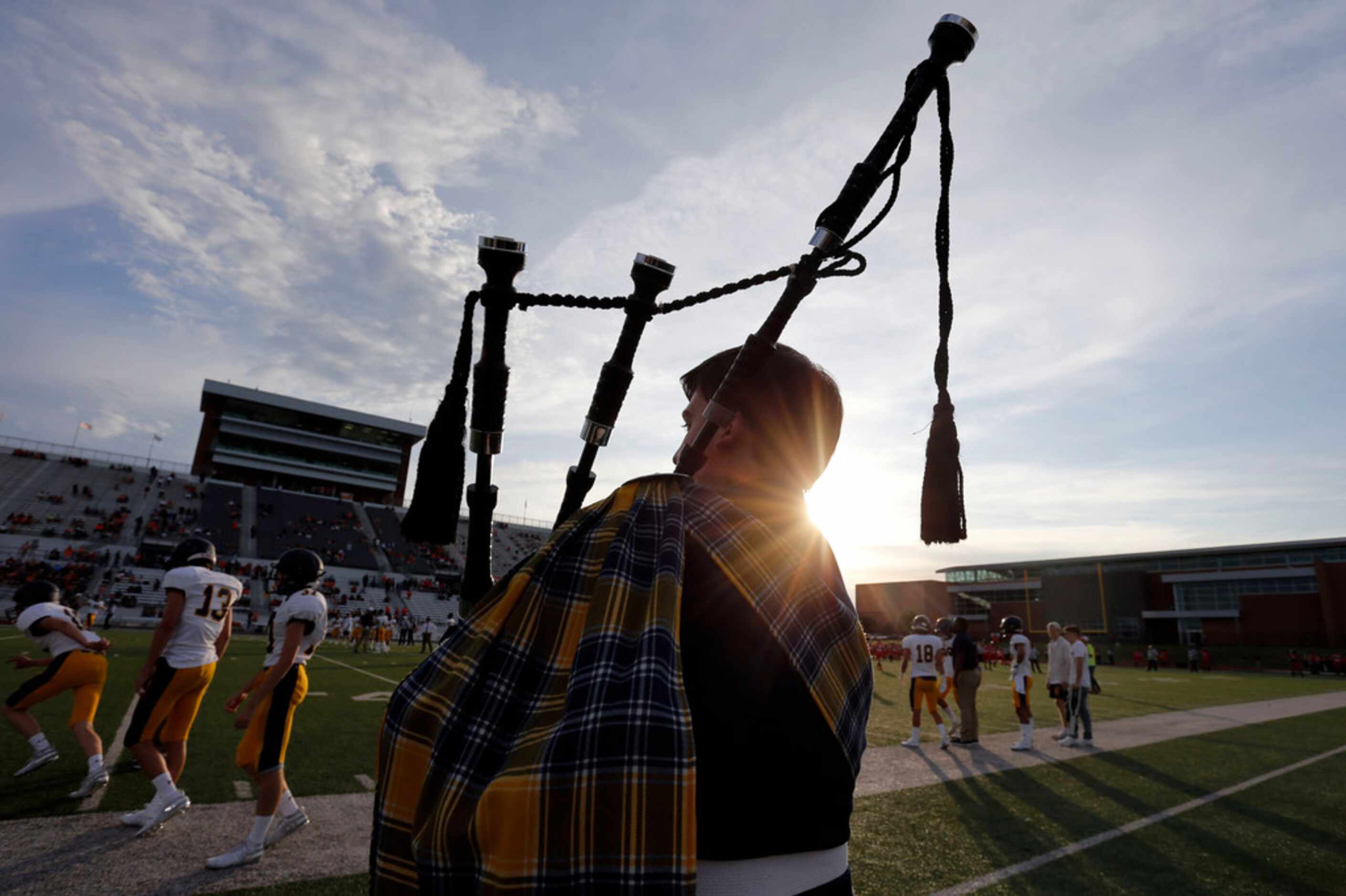 Bagpipe player Robert Tripplett serenades the team during pregame workouts before their high...