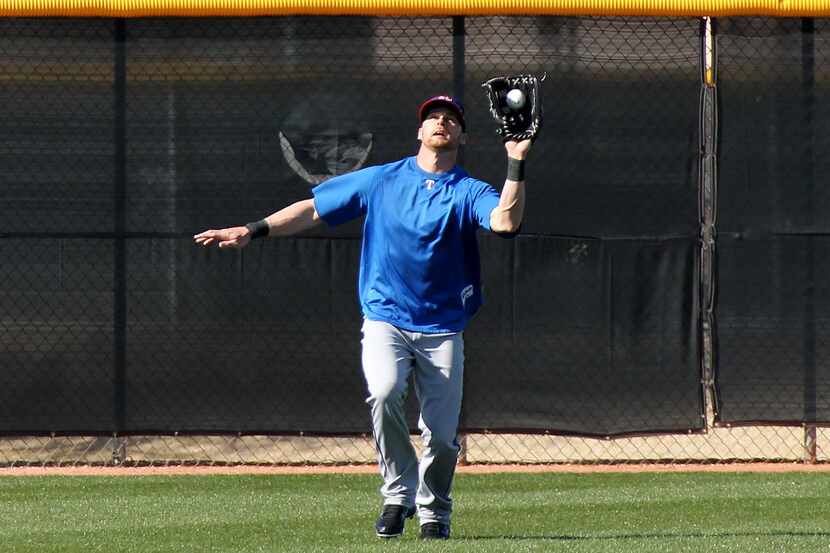 Texas outfielder Craig Gentry makes the catch on a long fly ball at the Texas Rangers spring...
