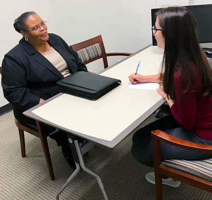 Woman meets with a counselor with a computer on the table between them.