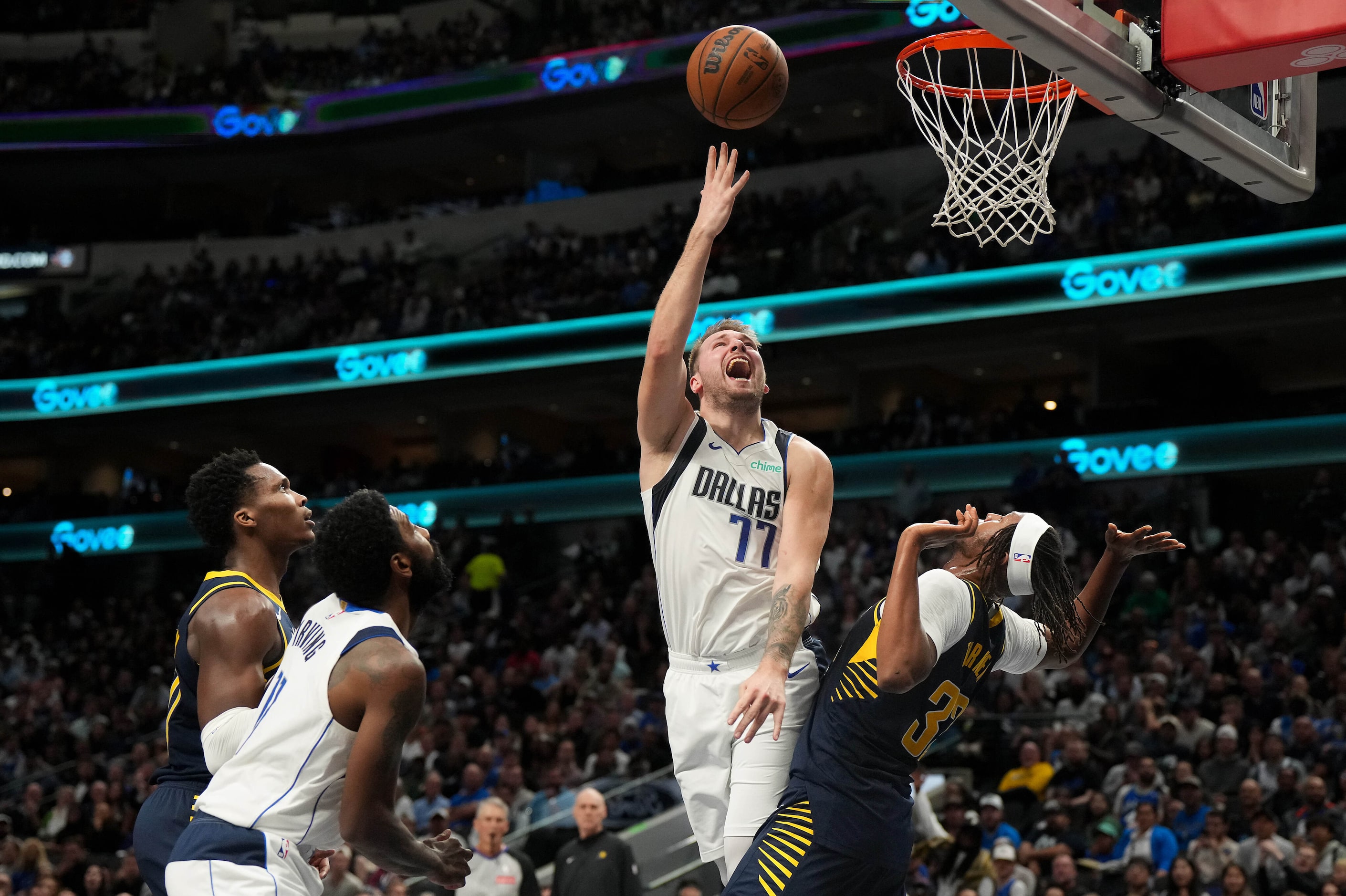 Dallas Mavericks guard Luka Doncic (77) shoots over Indiana Pacers center Myles Turner (33)...