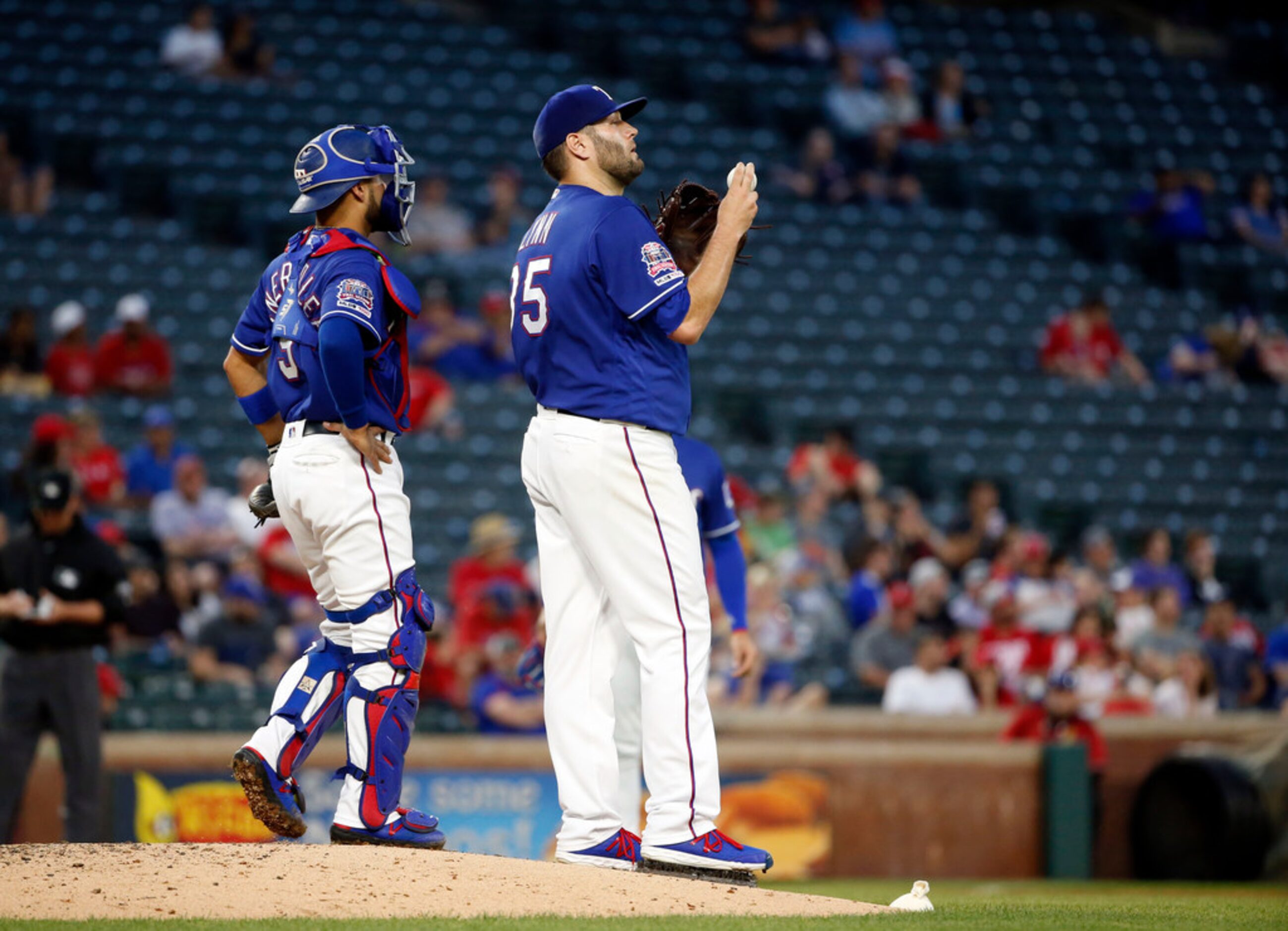 Texas Rangers catcher Isiah Kiner-Falefa (9) visits with starting pitcher Lance Lynn (35)...