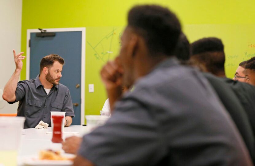 
Chef and Executive Director Chad Houser talks to interns during a family meal time before...