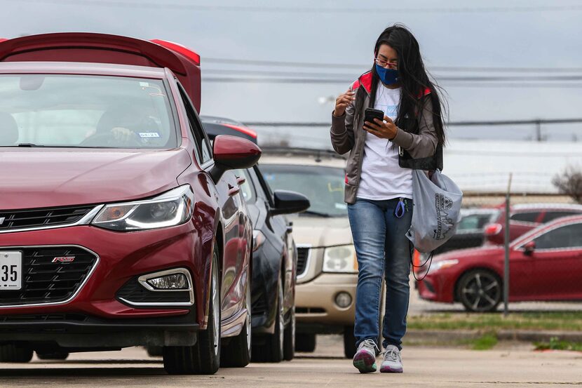 Leslie Armijo reaches out to people in line at Santa Teresita Catholic Church in Dallas on...