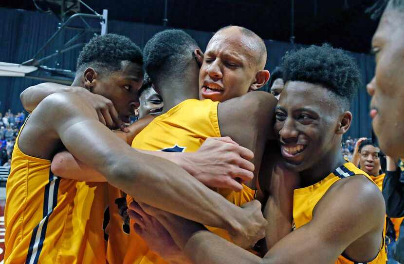 Oak Cliff Faith Academy's Jordan Walsh #23 is hugged by teammates after hitting game winning...