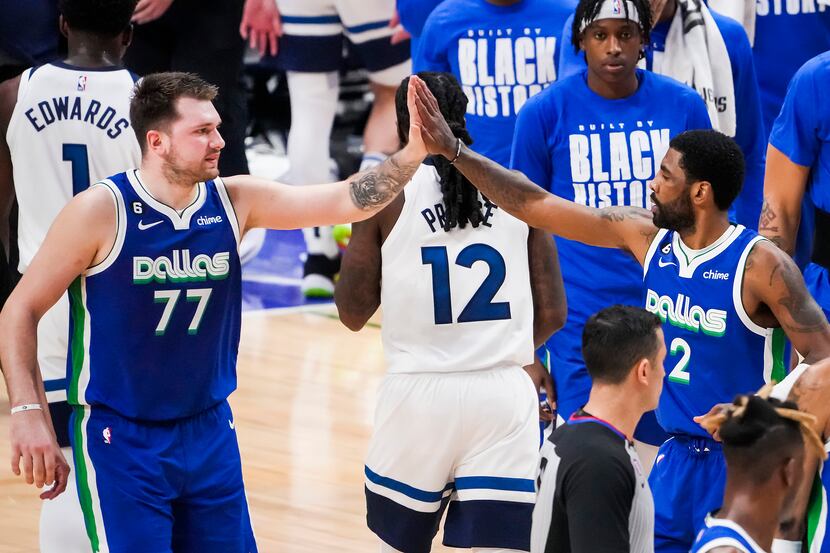 Dallas Mavericks guard Luka Doncic (77) high fives guard Kyrie Irving (2) during the first...