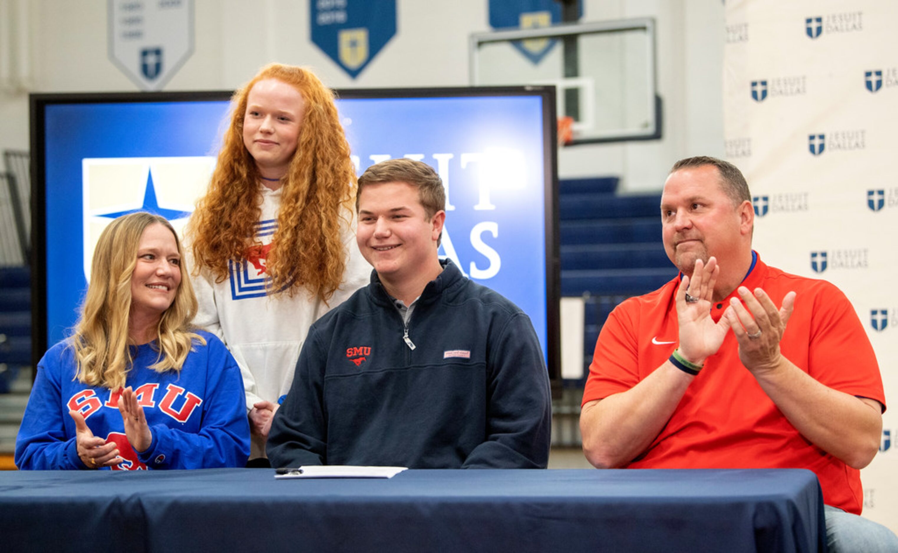 Jesuit senior center Branson Hickman is flanked by his father and Jesuit head football coach...