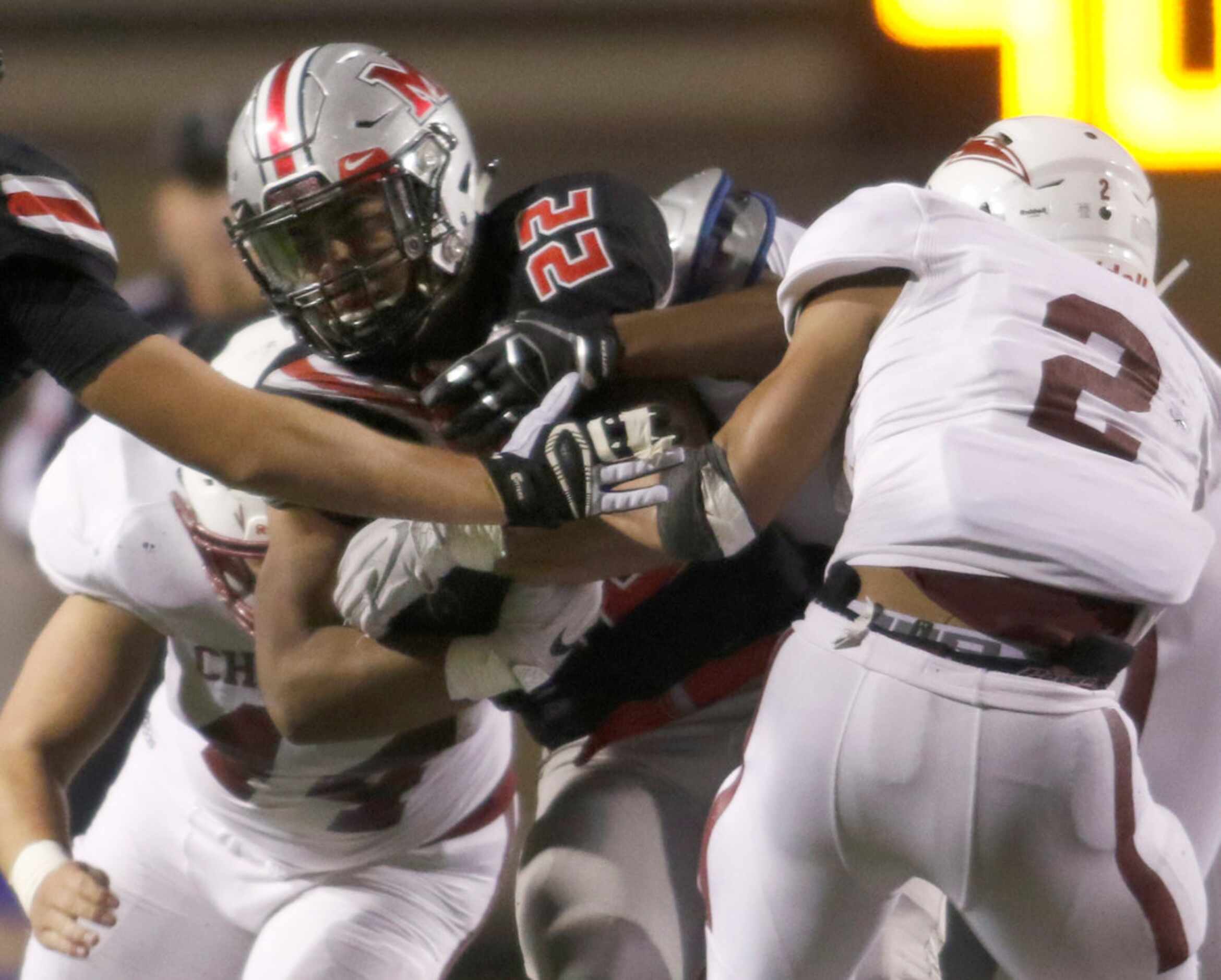 Flower Mound Marcus running back Ty'son Edwards (22) grinds out yardage as he is tackled by...