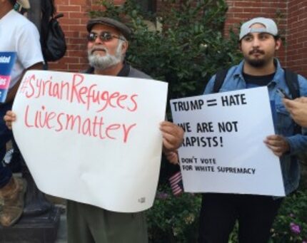  Dallas businessman Hadi Jawad held a sign in support of Syrian migrants. (Dianne Solis/staff)