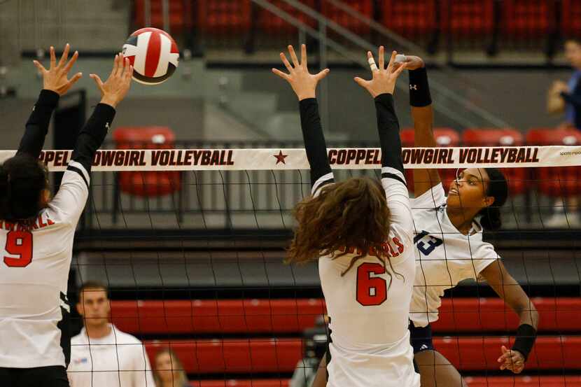 Flower Mound's Brianna Watson (13) spikes the ball as Coppell's Alena Truong (9) and...