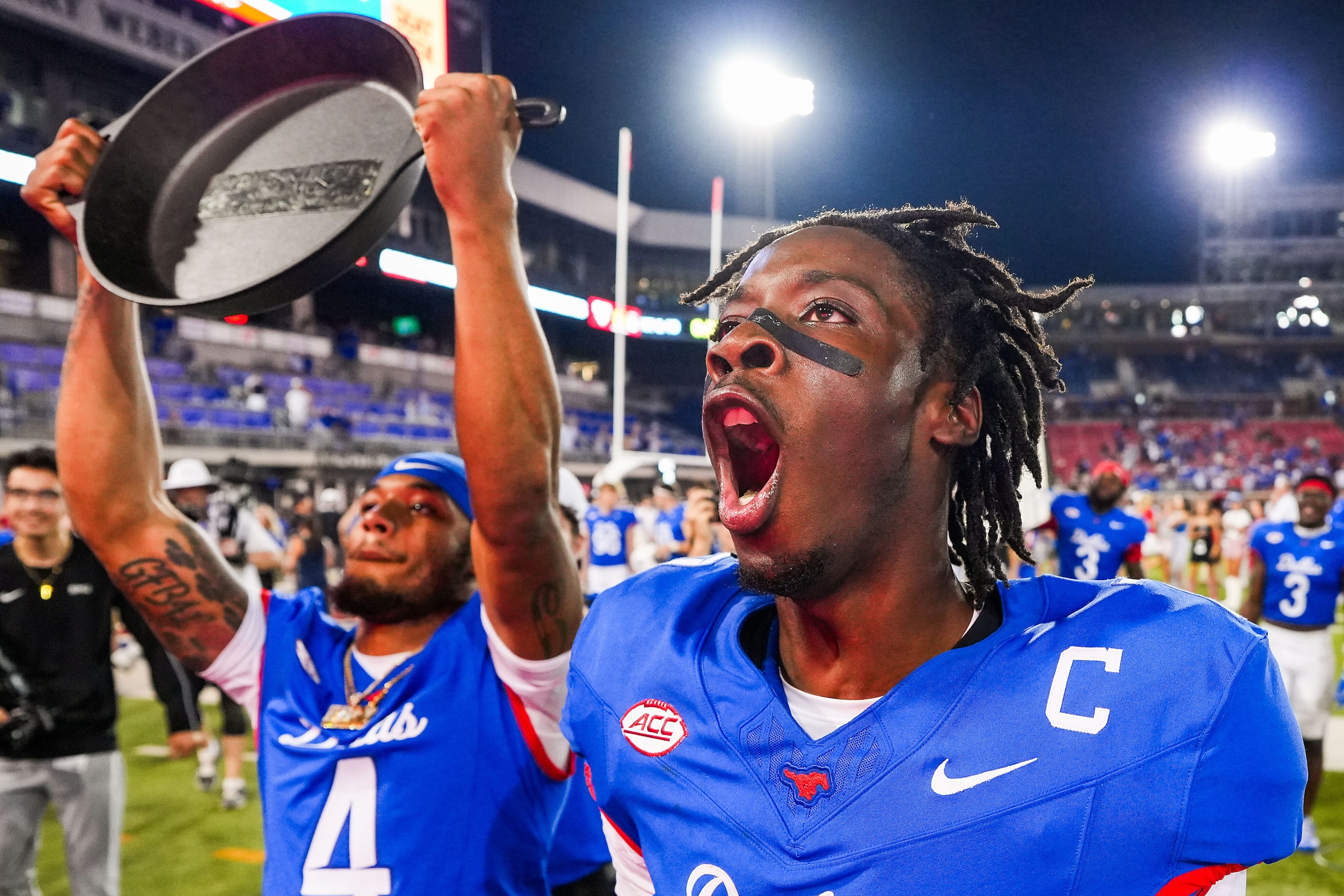 SMU quarterback Kevin Jennings (right) celebrates with running back Jaylan Knighton (4), who...