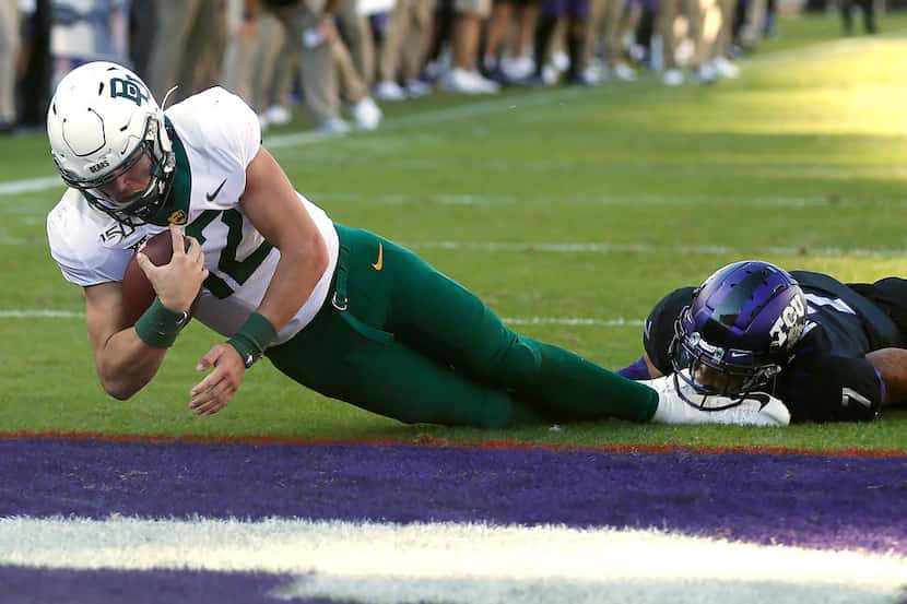Baylor quarterback Charlie Brewer (12) dives across the goal line to score a touchdown as...