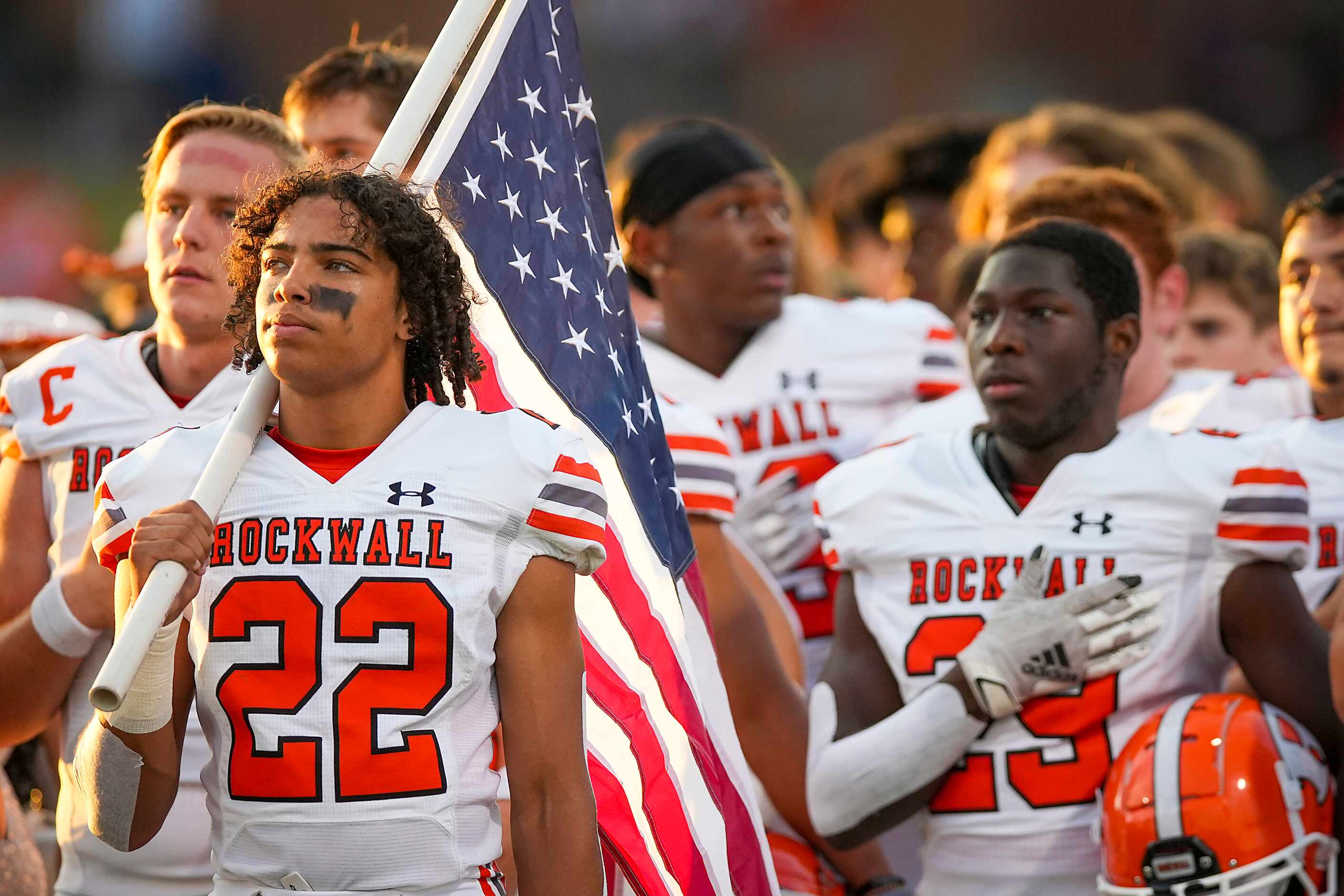 Rockwall running back  Parker Williams (22) holds the American flag as the team stands for...