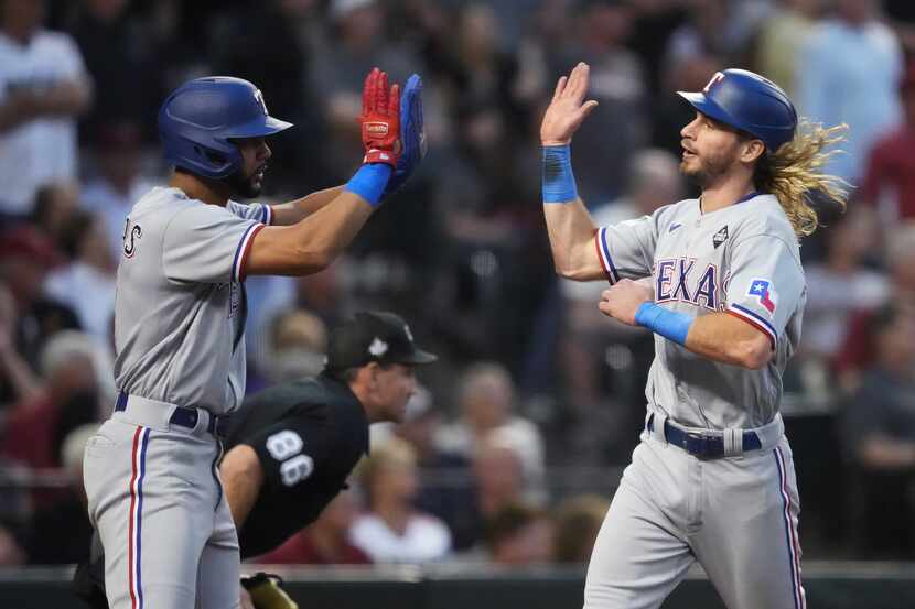 Texas Rangers’ Travis Jankowski, right, celebrates with Leody Taveras, left, after scoring...